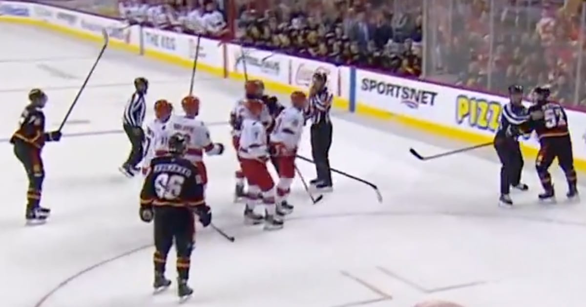 MacKenzie Weegar surrounded by Carolina Hurricanes players